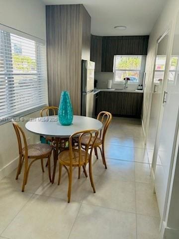 dining area featuring light tile patterned flooring and baseboards