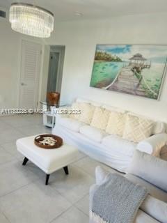 tiled living area featuring an inviting chandelier