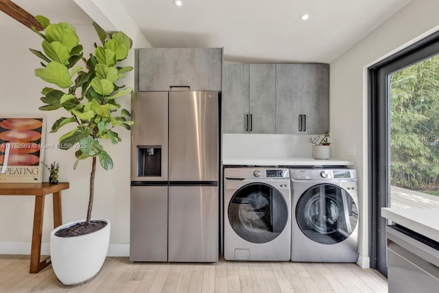 laundry area with light wood-type flooring, cabinet space, washer and dryer, and recessed lighting