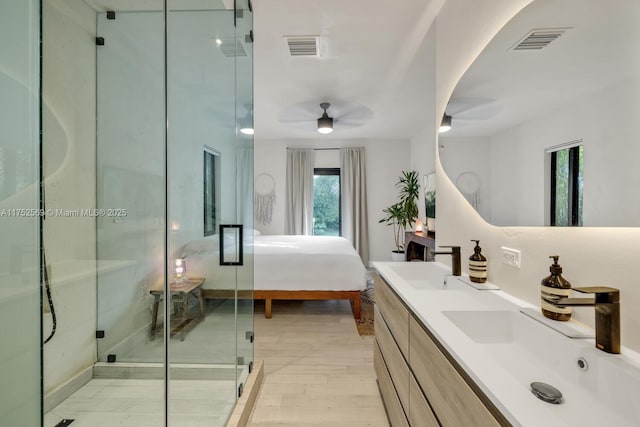 ensuite bathroom featuring double vanity, a sink, visible vents, and a shower stall