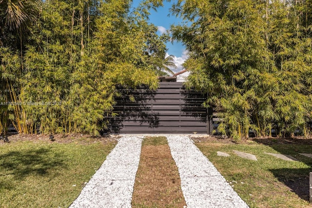 view of gate with a yard