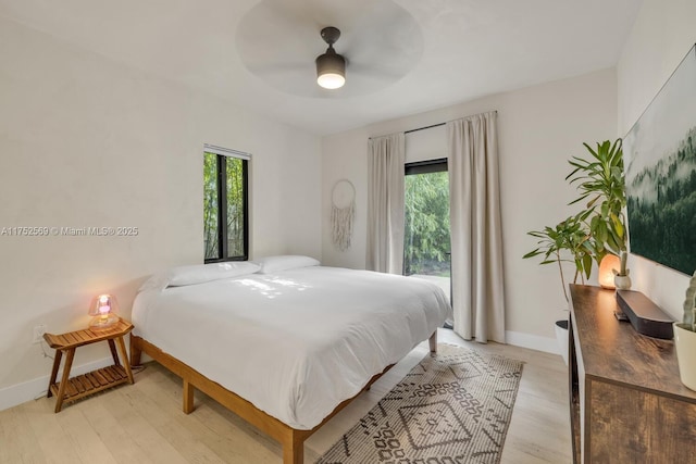 bedroom featuring a ceiling fan, baseboards, and light wood finished floors