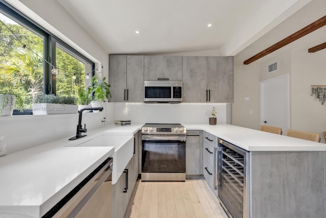 kitchen featuring visible vents, wine cooler, a peninsula, gray cabinets, and stainless steel appliances