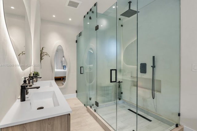 bathroom featuring recessed lighting, a sink, visible vents, a shower stall, and double vanity