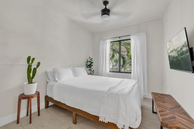 bedroom featuring light wood-style floors, ceiling fan, and baseboards