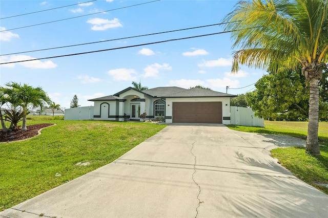 view of front of property with a garage, concrete driveway, a front yard, and stucco siding