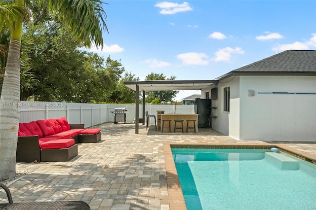 view of swimming pool with a fenced backyard, area for grilling, outdoor dry bar, a fenced in pool, and a patio area