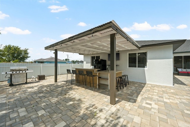 view of patio / terrace featuring fence, outdoor dry bar, and area for grilling