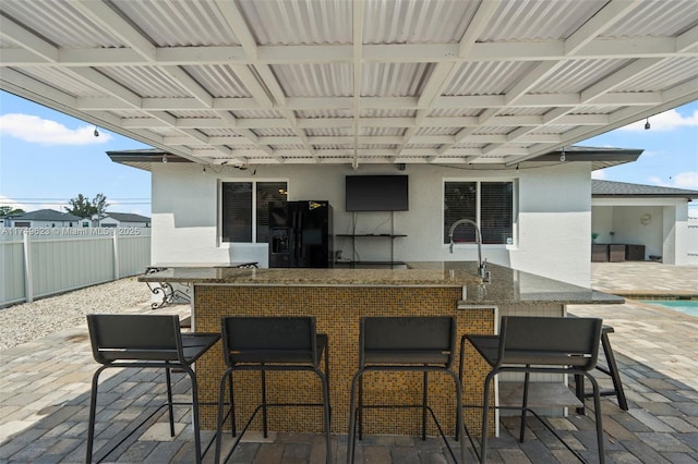 view of patio / terrace featuring fence and a bar