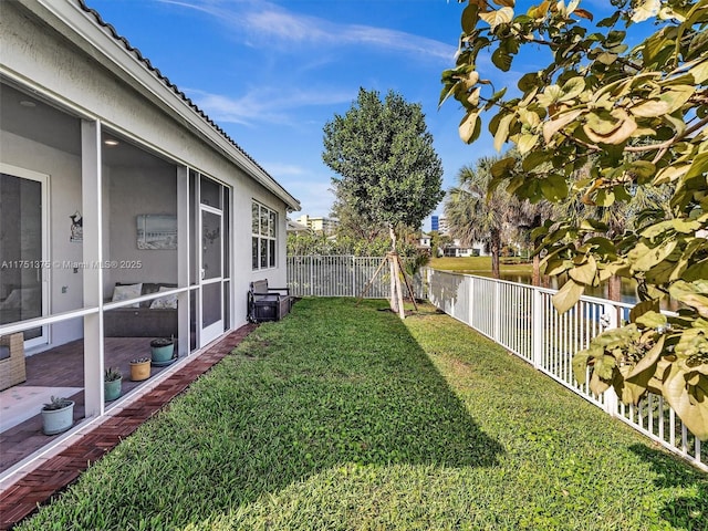 view of yard with a sunroom and a fenced backyard