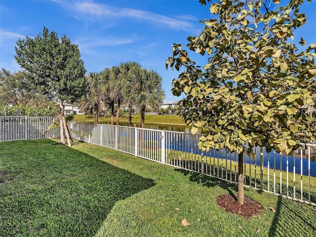 view of yard with a water view and a fenced backyard