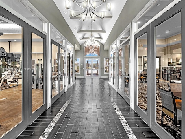 sunroom / solarium featuring lofted ceiling, french doors, and a notable chandelier