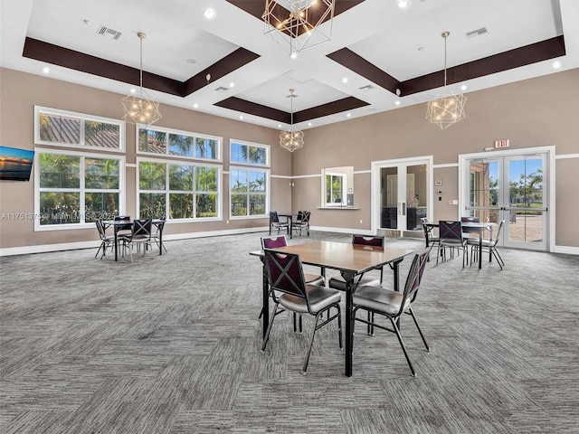 dining room featuring carpet floors, a towering ceiling, visible vents, and french doors