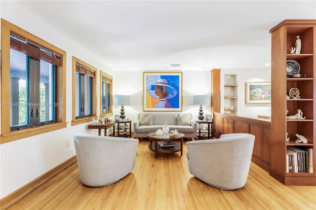 living area with visible vents and wood finished floors