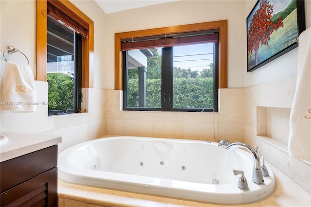 bathroom featuring a tub with jets and vanity