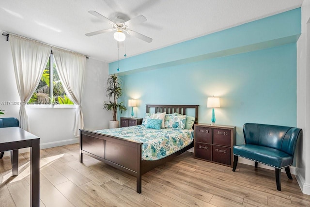 bedroom with a ceiling fan, baseboards, and wood finished floors