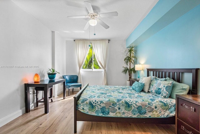 bedroom with light wood-type flooring, baseboards, and a ceiling fan