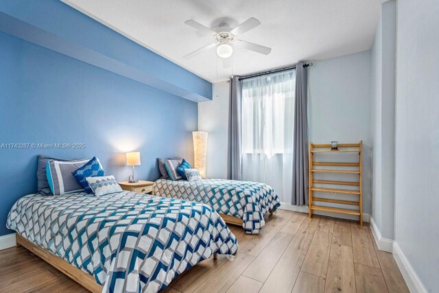 bedroom featuring ceiling fan, wood finished floors, and baseboards