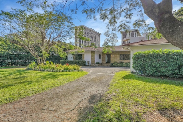 view of front of house with driveway and a front lawn