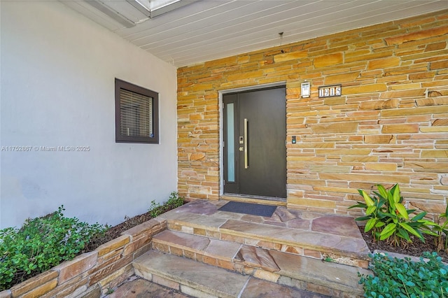 entrance to property featuring elevator and brick siding