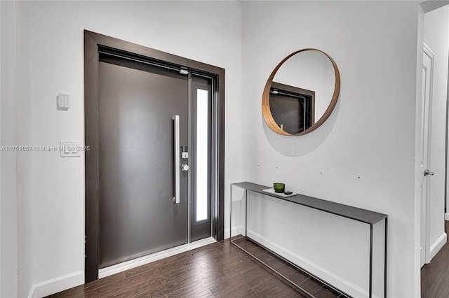 foyer entrance with dark wood-style floors and baseboards