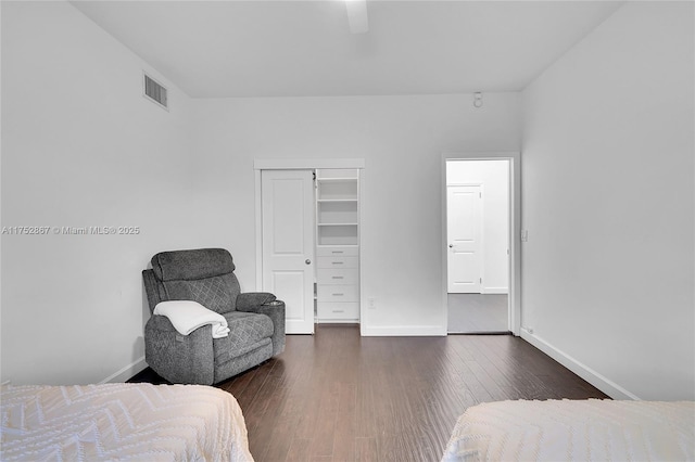 bedroom with a closet, visible vents, dark wood finished floors, and baseboards