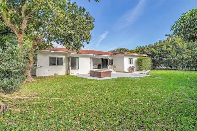 rear view of house featuring a patio, crawl space, a lawn, and stucco siding