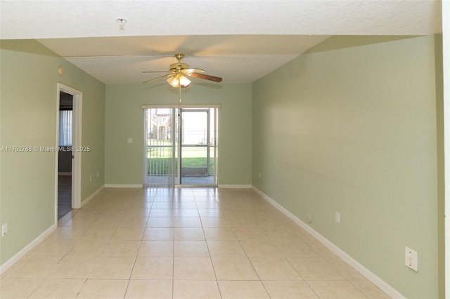 unfurnished room featuring ceiling fan, light tile patterned floors, and baseboards