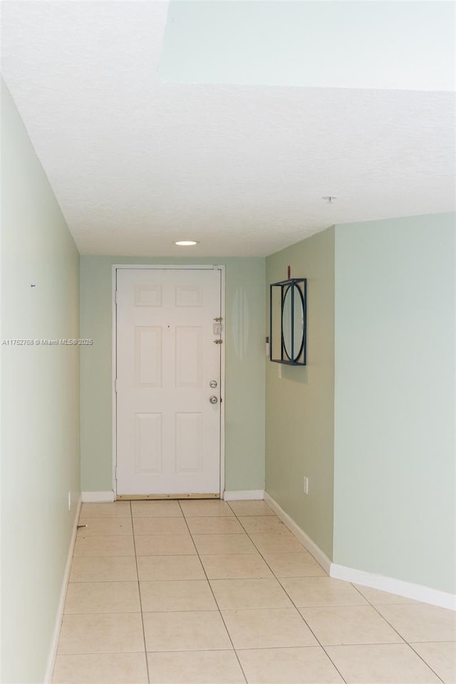 interior space featuring light tile patterned floors and baseboards