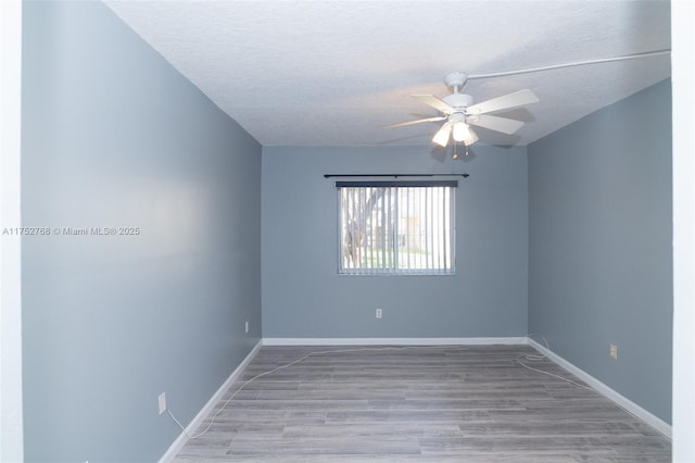 spare room with a ceiling fan, a textured ceiling, baseboards, and wood finished floors