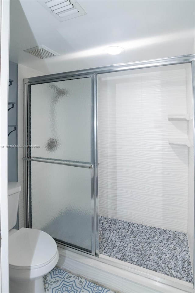 full bath featuring a stall shower, visible vents, and toilet