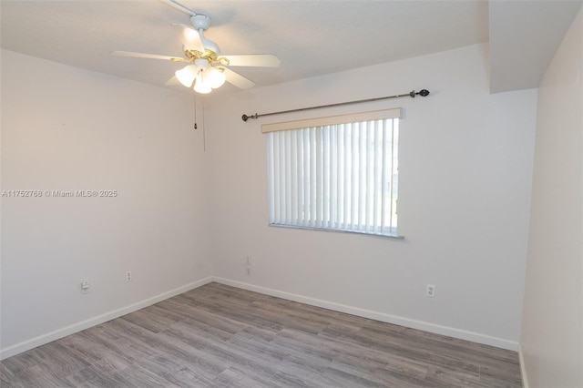 empty room with ceiling fan, wood finished floors, and baseboards