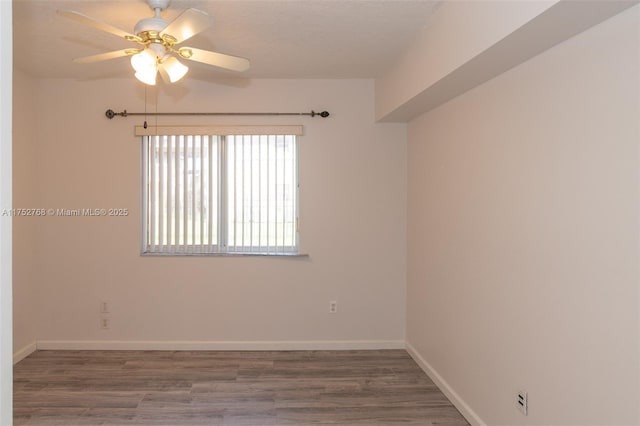 spare room with a ceiling fan, baseboards, and wood finished floors