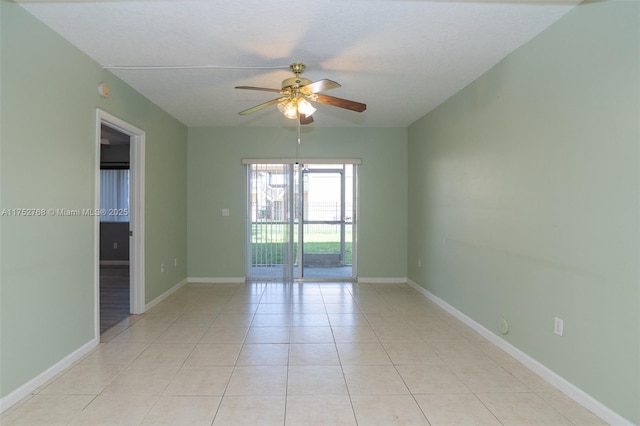 unfurnished room featuring ceiling fan, light tile patterned flooring, and baseboards