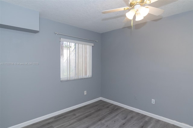 unfurnished room with a textured ceiling, wood finished floors, a ceiling fan, and baseboards