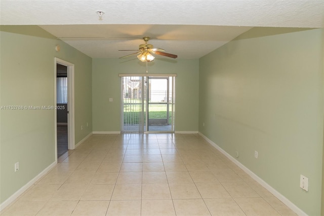 spare room featuring ceiling fan, baseboards, a textured ceiling, and light tile patterned flooring