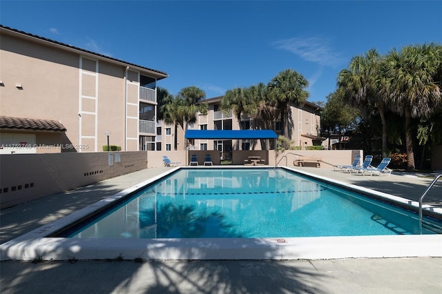 pool with a patio and fence