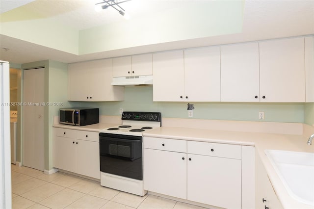 kitchen with light tile patterned flooring, under cabinet range hood, range with electric stovetop, a sink, and stainless steel microwave