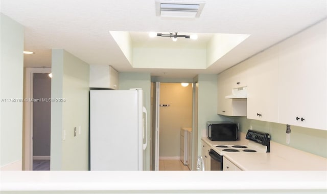 kitchen with washer / clothes dryer, light countertops, electric range, freestanding refrigerator, and under cabinet range hood