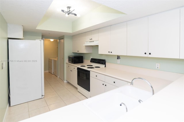 kitchen featuring light tile patterned floors, white cabinets, white appliances, independent washer and dryer, and under cabinet range hood