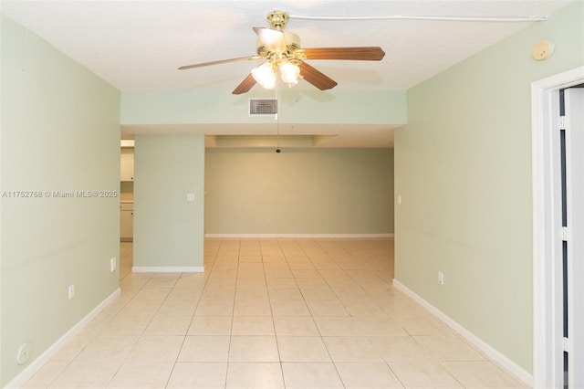 empty room with light tile patterned floors, baseboards, visible vents, and a ceiling fan