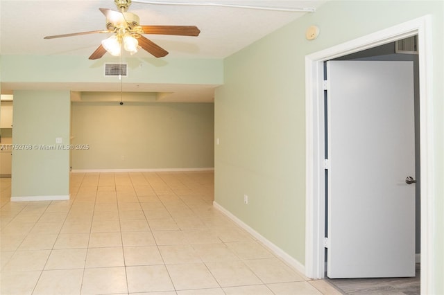 spare room with visible vents, ceiling fan, baseboards, and light tile patterned floors