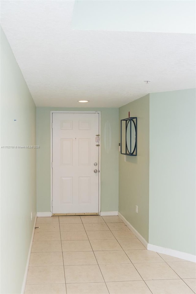 entryway featuring baseboards and light tile patterned floors