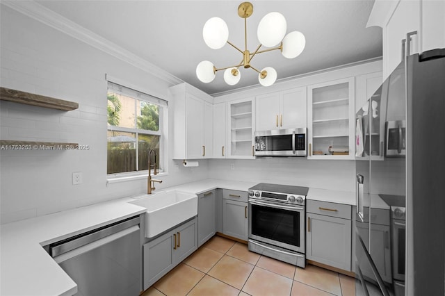 kitchen with light tile patterned floors, glass insert cabinets, appliances with stainless steel finishes, gray cabinets, and a sink