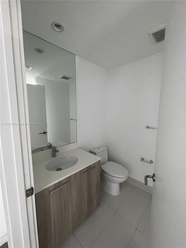 bathroom featuring vanity, tile patterned floors, toilet, and visible vents