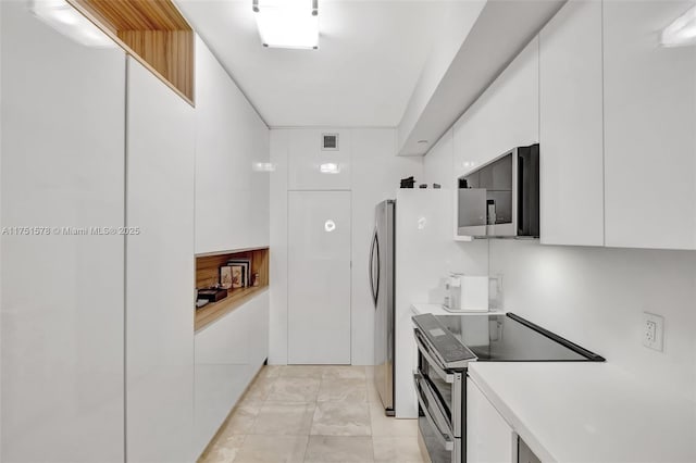 kitchen with light countertops, visible vents, appliances with stainless steel finishes, white cabinets, and modern cabinets