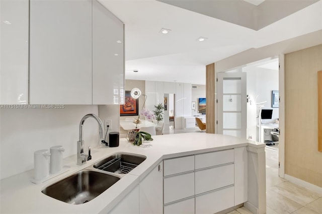 kitchen with a sink, a peninsula, and modern cabinets