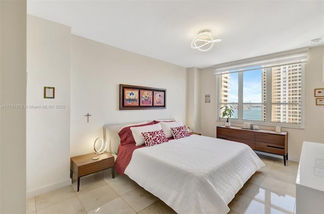 bedroom featuring light tile patterned flooring and baseboards