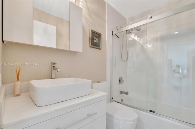 bathroom with toilet, bath / shower combo with glass door, and vanity