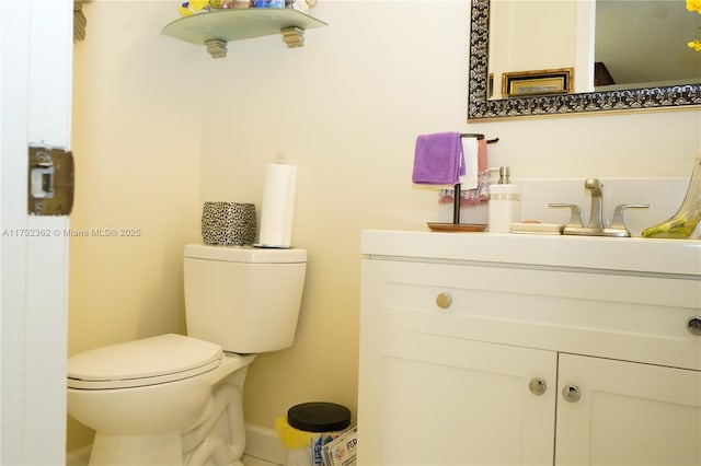 bathroom with vanity, toilet, and baseboards